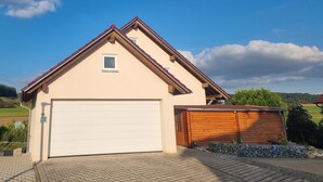 A single-story house with a garage, a small window, and a wooden shed. - Holiday Apartment "Biosphärenblick" with Private Terrace, Shared Garden and Wi-Fi (Münsingen)