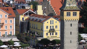 A historic building with a tower, a hotel named 'Hotel Helvetia,' and a restaurant named 'Cold Restaurant.' - Studio 'Sandra Scheck' with Mountain View, Private Terrace & Wi-Fi (Lindau am Bodensee)