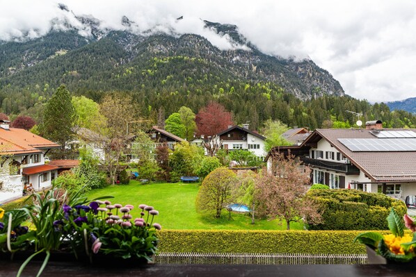 Un quartier résidentiel avec des maisons, une pelouse bien entretenue et une chaîne de montagnes en arrière-plan.