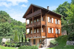 Un immeuble en bois à plusieurs étages, doté de balcons et entouré de verdure.