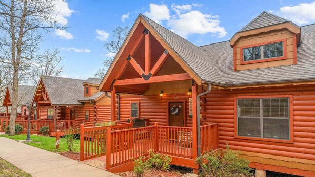 A log cabin-style hotel with a porch, a covered entryway, and a visible room number.