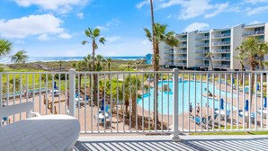 A pool area with lounge chairs and a view of the ocean. - Sandcastle Condominiums Unit 217 (Port Aransas)