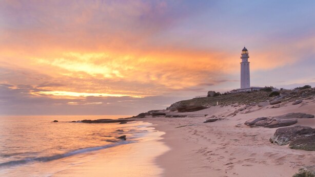 A lighthouse on a sandy beach with a sunset in the background. - Villa del Fresno with pool and parking (Chiclana)