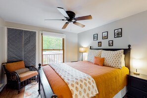 Relax in this serene bedroom with a large bed, ceiling fan, and comfortable seating area.