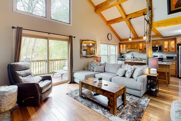 Relax in this airy living space with a sectional sofa, recliner, and small table, offering a comfortable spot to unwind.