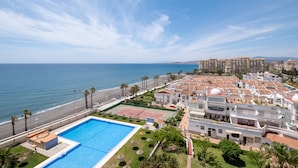 Hotel à beira-mar com piscina, quadra de tênis e vista para o oceano.