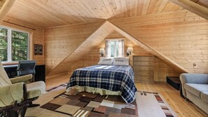 Une chambre confortable située dans les combles, avec un lit, deux tables de chevet, une chaise et un bureau.