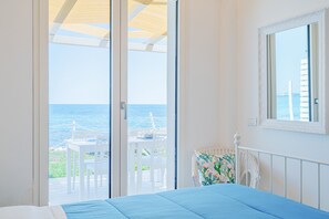 Une chambre à coucher avec un lit, une fenêtre et une vue sur la mer.