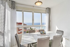 A dining area with a table, chairs, and a laptop on the table.