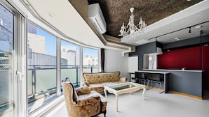Een moderne woonkamer met een bank, een glazen salontafel en een rode accentmuur.