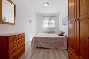 A bedroom with a bed, wooden wardrobe, and a dresser. - Vacation Home "Tanai" close to the Beach with Private Terrace (El Cotillo)