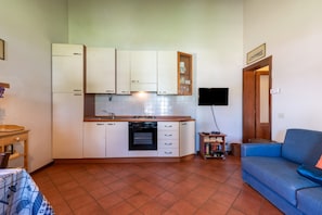 A compact kitchen with white cabinets, a built-in oven, and a tiled backsplash. - Farmhouse "Officina" with Shared Pool, Private Terrace & Wi-Fi (Laterina)