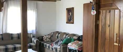 Un interior de madera con un sofá, una mesita y un armario.