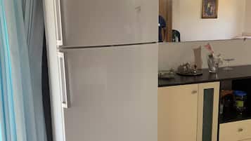 A kitchen with a white refrigerator, a sink, and a cabinet.