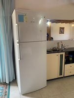 A kitchen with a white refrigerator, a sink, and a cabinet.