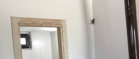 Ein Badezimmer mit Toilette, Dusche und einem spiegel mit Holzrahmen.