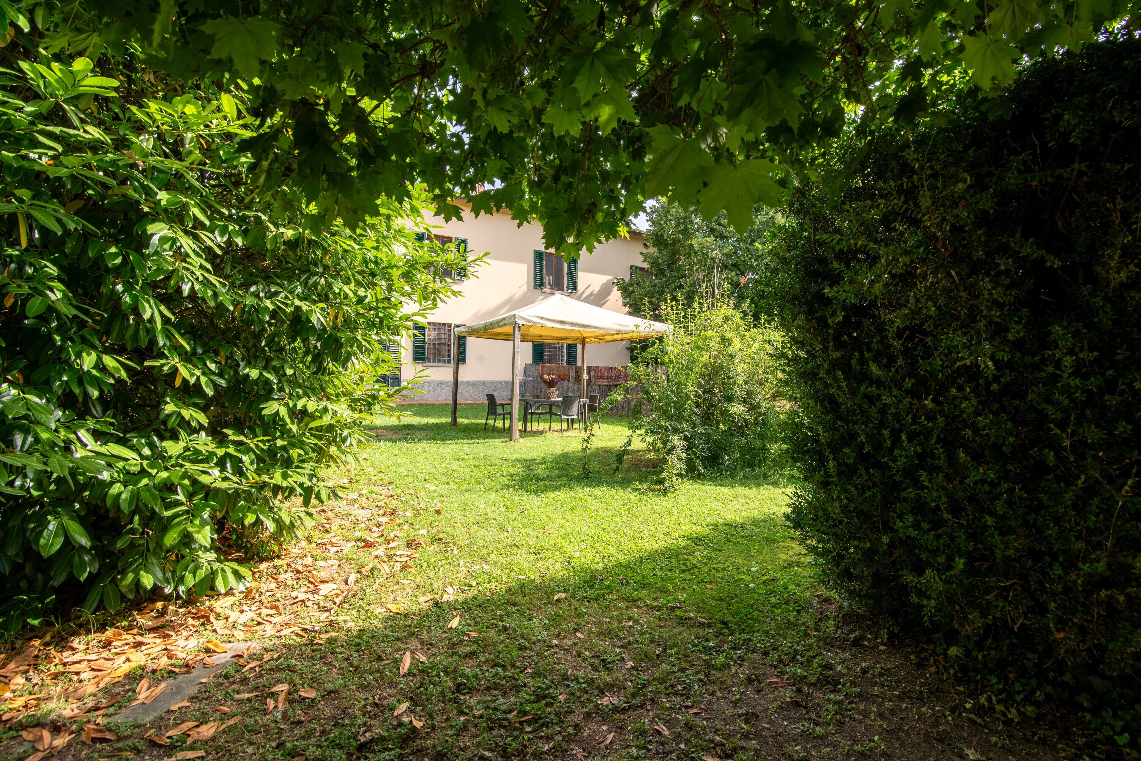 Ein Haus mit einer überdachten Terrasse, umgeben von üppigem Grün.