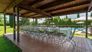 A covered outdoor patio with a pool table, chairs, and umbrellas. - Farmhouse "Fattoria" with Shared Pool, Private Garden & Wi-Fi (Laterina)