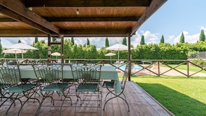 An outdoor covered patio with a pool, green chairs, and umbrellas. - Farmhouse 'Mulino ' with Shared Pool, Terrace & Wi-Fi (Laterina)
