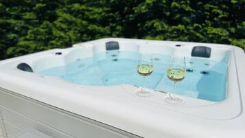 A hot tub with two glasses of wine.