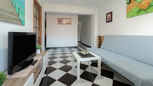 A living room with a TV, sofa, and a checkered floor.