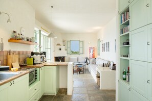 Una cocina con comedor, un sofá y una estantería.