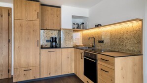 Een moderne keuken met houten kastjes, een roestvrijstalen spoelbak en een inbouwoven.