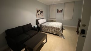 Una camera da letto compatta con un letto, un divano e un tavolino.