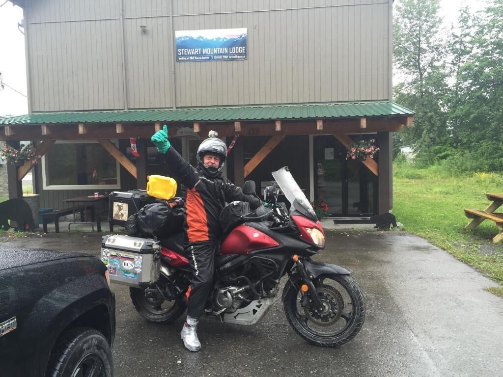 A person on a motorcycle parked in front of a building labeled "Steve Mountain Lodge".
