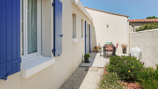 A narrow outdoor corridor with a gravel path, a potted plant, and a chair. - Holiday Home "Begognias" with Private Terrace (LE CHATEAU-D'OLERON)