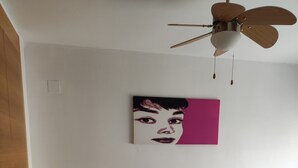 A bedroom with a bed, two bedside tables, a ceiling fan, and a wall-mounted artwork. - Apartment "Jorro" with Shared Pool & Terrace (El Verger)