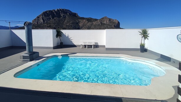 A rooftop pool with a clear view of a mountain in the background. - Apartment "Jorro" with Shared Pool & Terrace (El Verger)