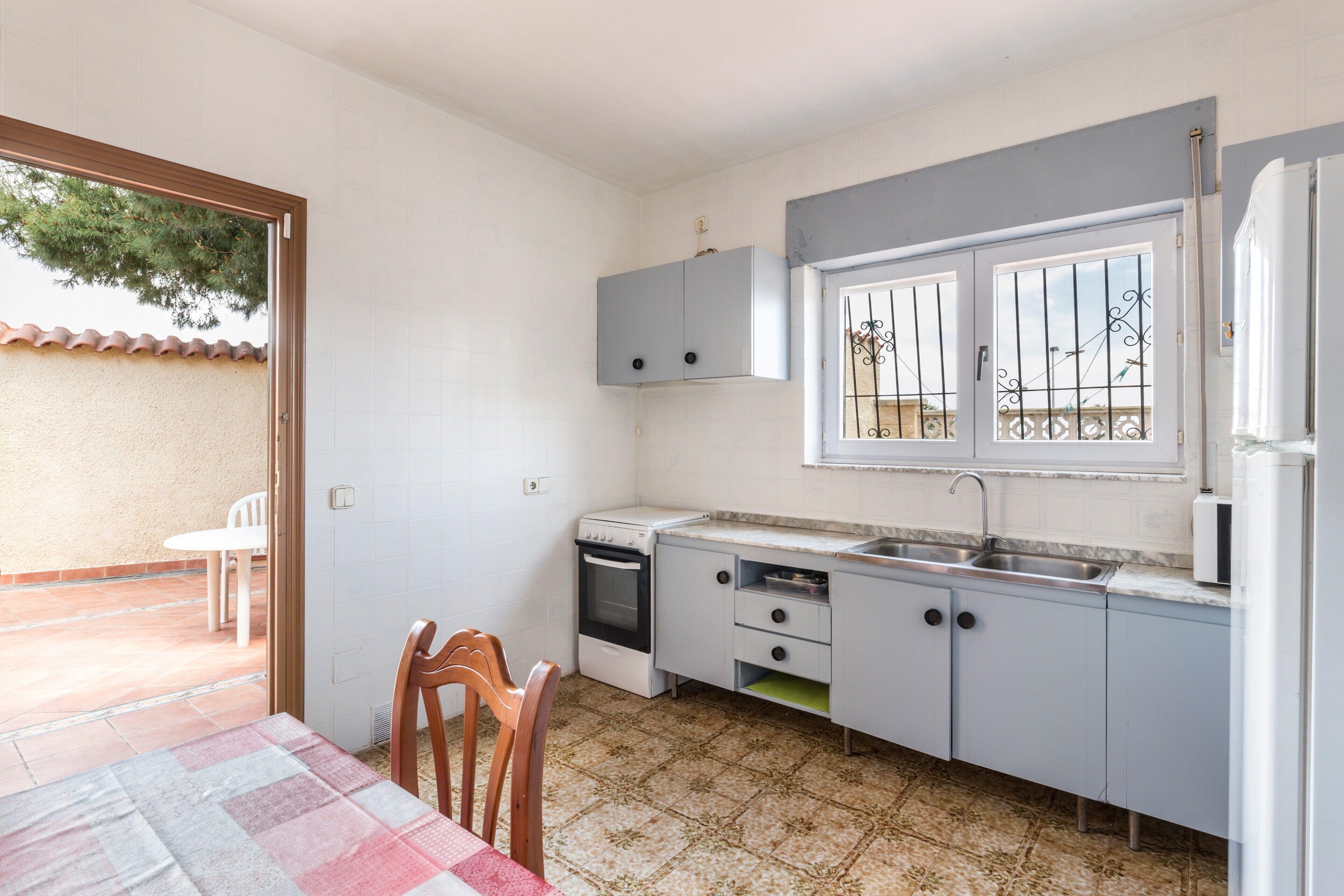 Una cocina compacta con comedor, una ventana con rejas y vistas al exterior.