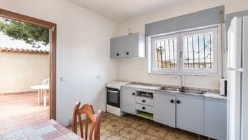 Una cocina compacta con comedor, una ventana con rejas y vistas al exterior.