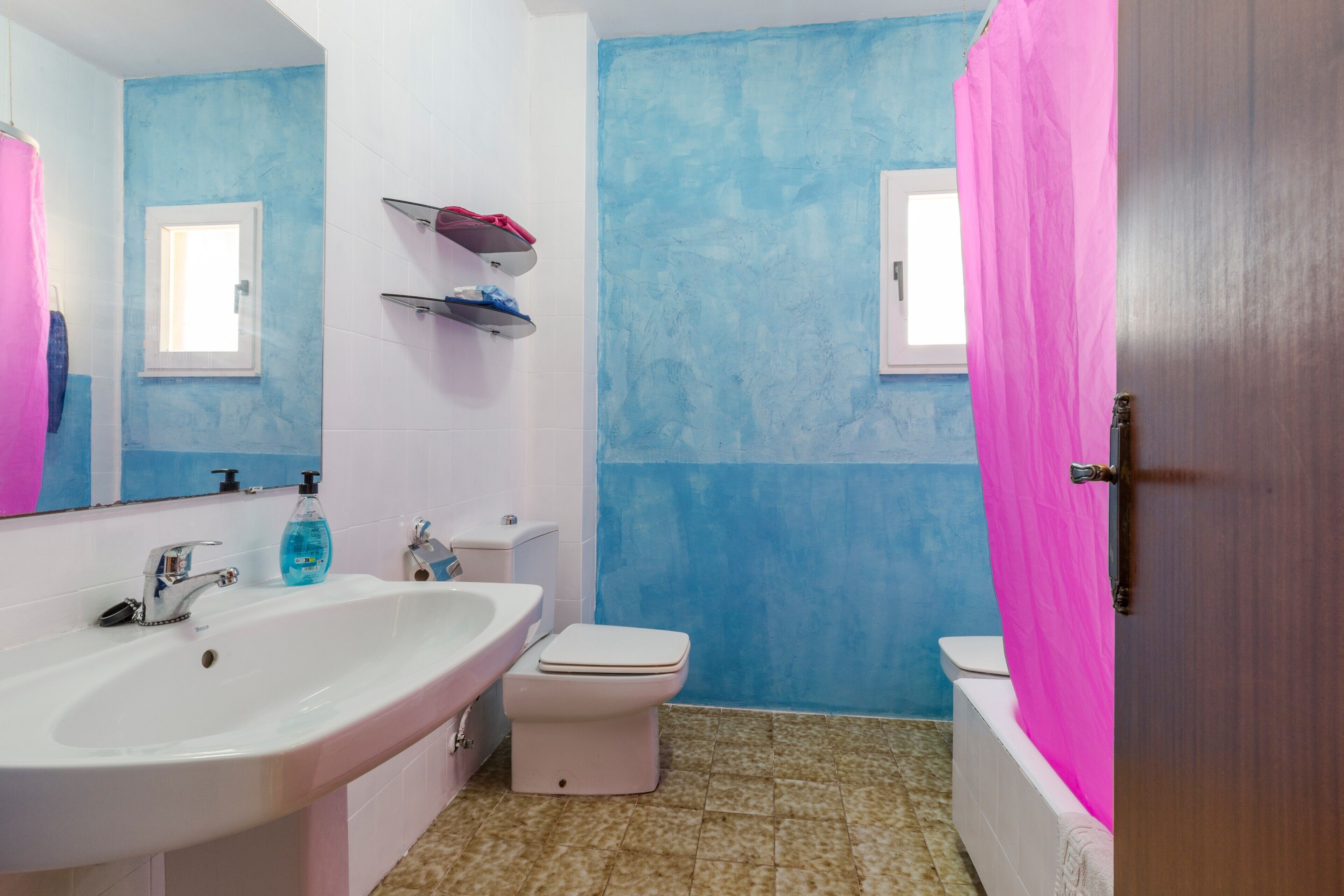 A bathroom with a sink, toilet, and shower curtain.