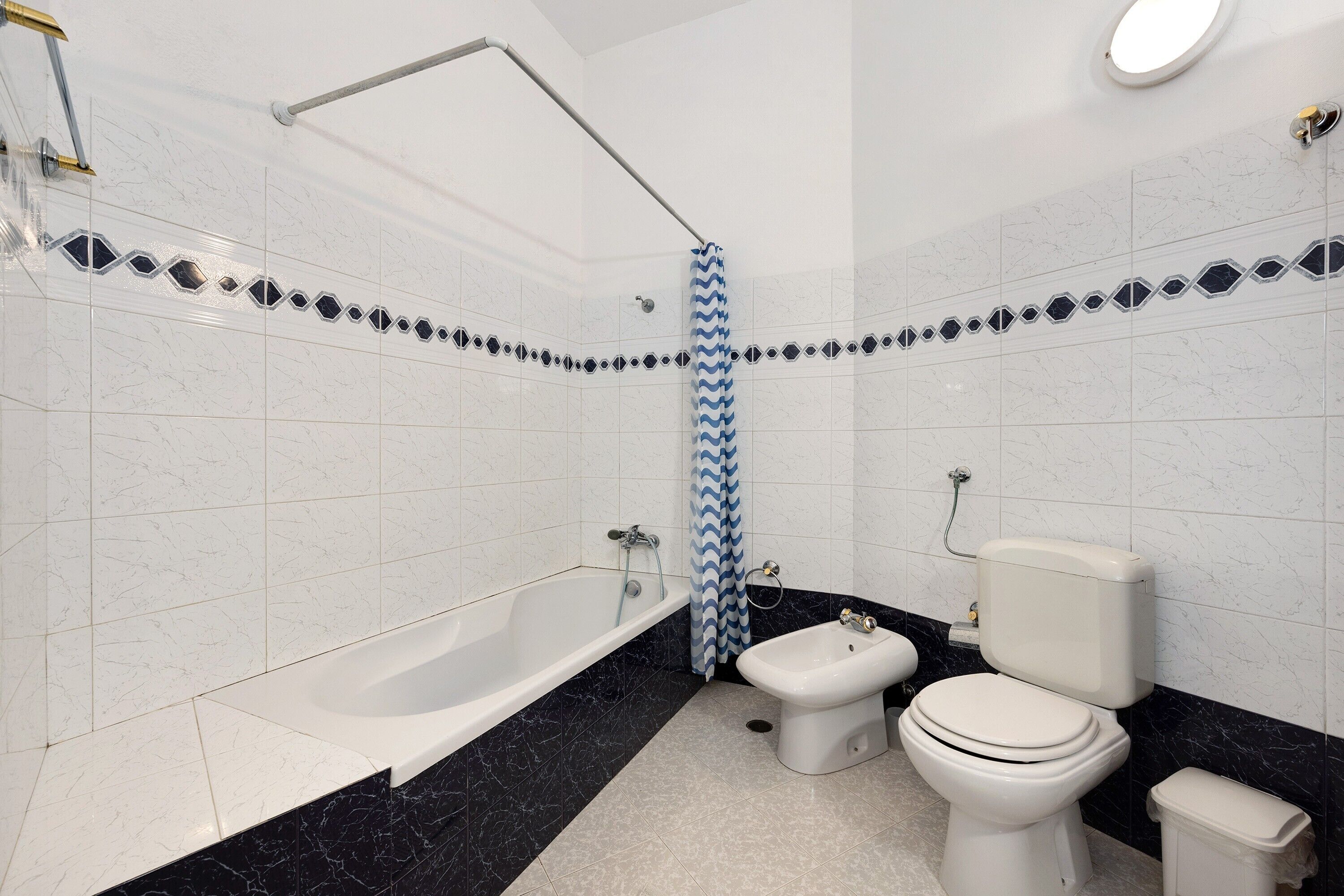 A bathroom with a bathtub, a bidet, and a toilet.