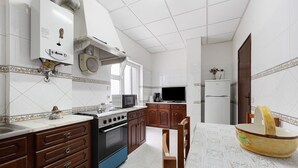 Cozinha equipada com fogão, micro-ondas e armários.
