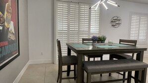 Un comedor con mesa, sillas y una lámpara colgante.