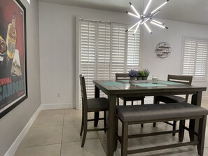 Enjoy meals in this dining area with a table and four chairs, a placemat, and a small potted plant.
