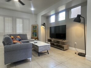 Relax in this stylish living room with a sofa, coffee table, and flat-screen TV.