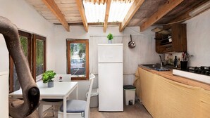 Une cuisine compacte équipée d’un réfrigérateur, d’un évier et d’une cuisinière. Une fenêtre offre une vue sur l  ’extérieur.