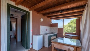 Una cocina compacta con refrigerador, lavabo y mesa de madera.