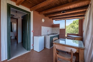 Una cuina compacta amb nevera, rentavaixelles i taula de fusta.