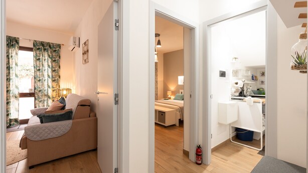 Um interior moderno com sofá, cama, cozinha e mesa de jantar.