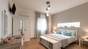 Quarto com cama, mesas de cabeceira, escrivaninha e guarda-roupa.