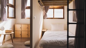 A room with a bed, a small table, a mirror, and a wardrobe. - TUNGWEI38 HOSTEL (Magong)