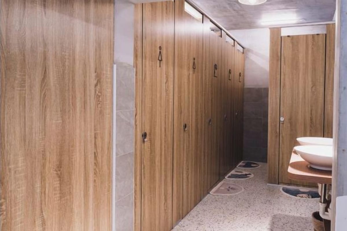 Ein Badezimmer mit Holzschränken, einem Waschbecken und einer Duschkabine.