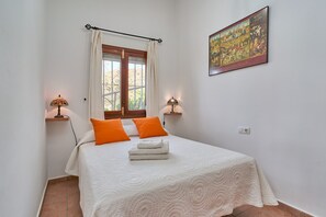A bedroom with a bed, two lamps, a window with curtains, and a painting on the wall. - Holiday Home "Torre del Manzano" with Mountain View, Private Pool & Wi-Fi (Torrox)