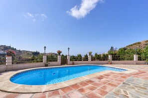 A swimming pool with a tiled deck, surrounded by a fence, and overlooking a hilly landscape. - Holiday Home "Torre del Manzano" with Mountain View, Private Pool & Wi-Fi (Torrox)