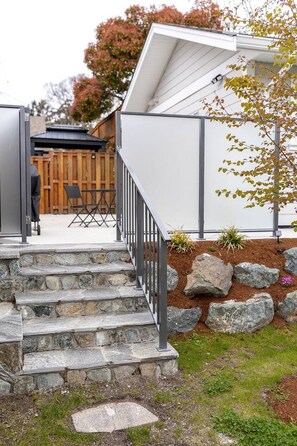 A stone staircase leading to a covered outdoor area with a metal railing.